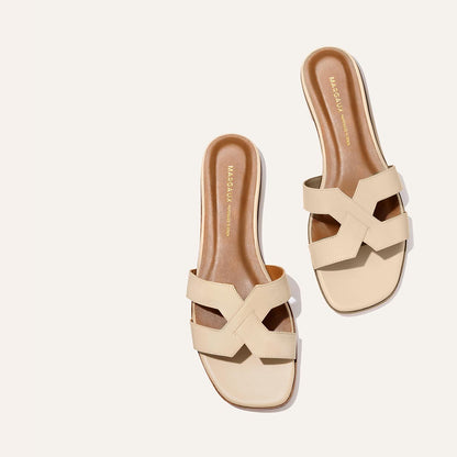 The MX Sandal - Latte Calf by Margaux features wide, crisscross beige straps and brown insoles, perfect for elevated everyday style, shown against a light background.