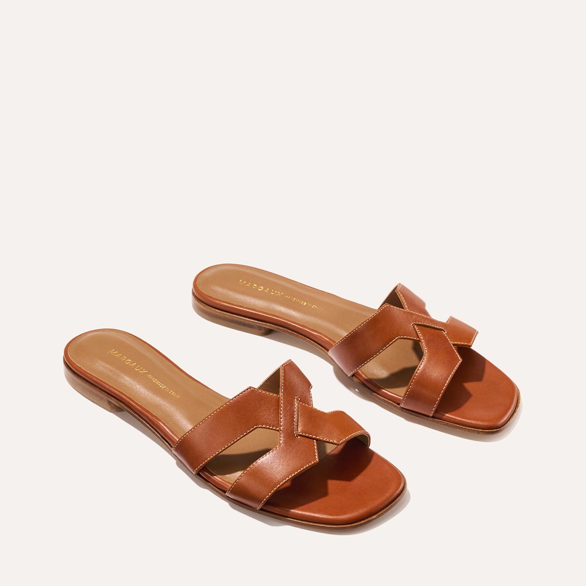 The MX Sandal in smooth saddle nappa leather, a slip-on sandal featuring embossed Italian leather with structured straps and a subtly square toe.