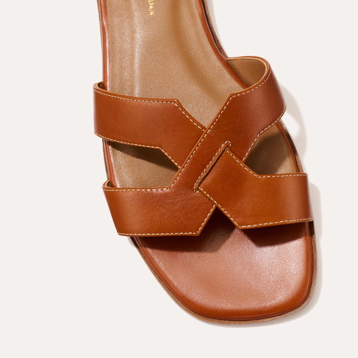 The MX Sandal in smooth saddle nappa leather, a slip-on sandal featuring embossed Italian leather with structured straps and a subtly square toe.