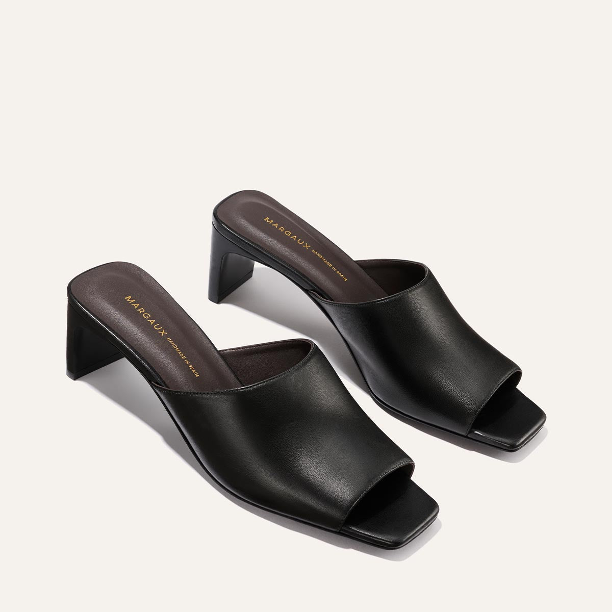 The Naomi 50 by Margaux: black nappa leather slip-on sandals with open square toe and mid-height square block heel, shown on a plain light background.