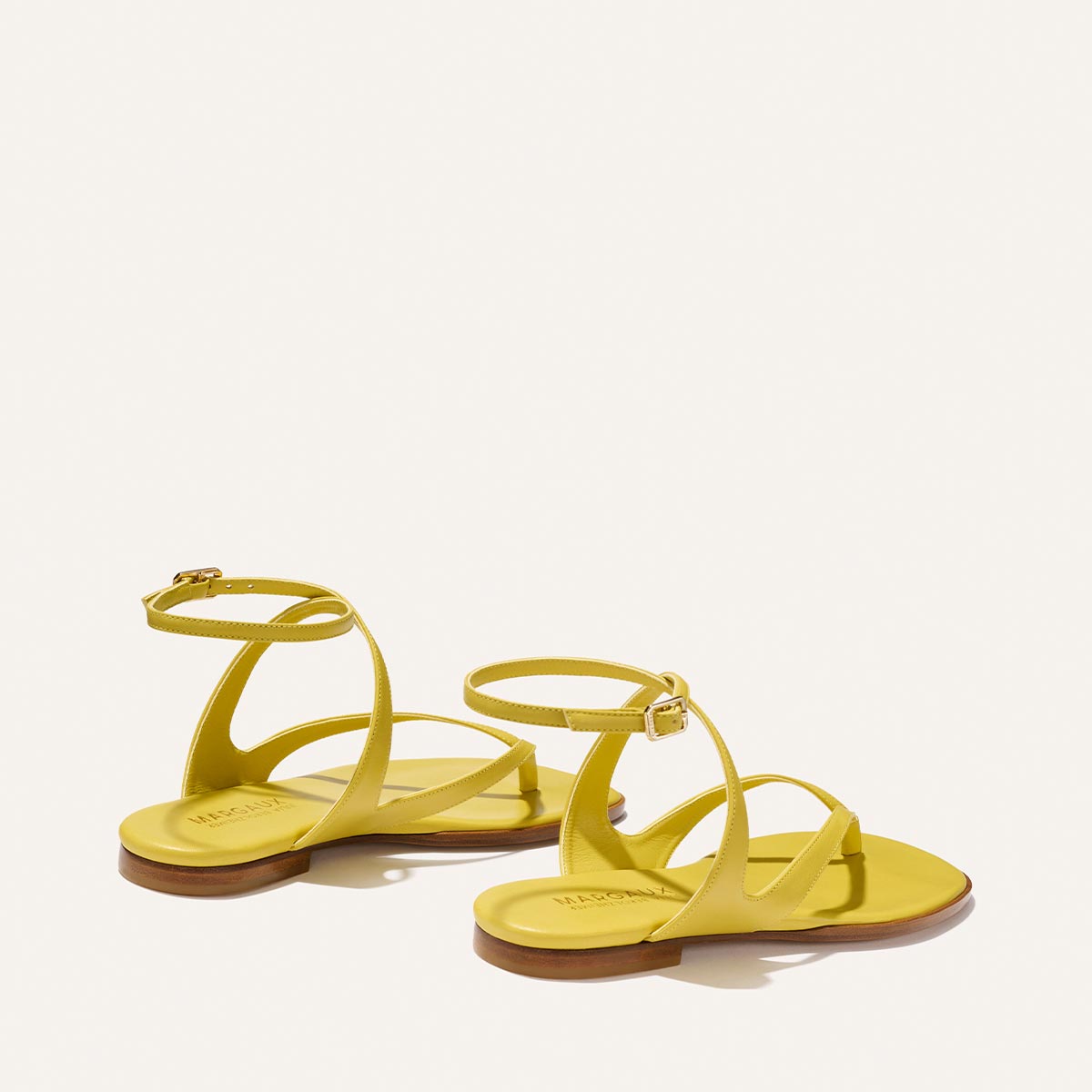 The Palermo Sandal - Chartreuse Nappa by Margaux, featuring thin straps and ankle buckles, brings playful sophistication to your look on a light background—a style inspired by Julia Berolzheimer.