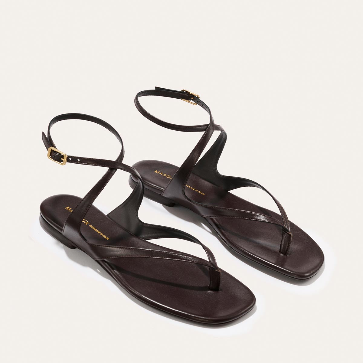 Pair of espresso nappa sandals on a light gray background