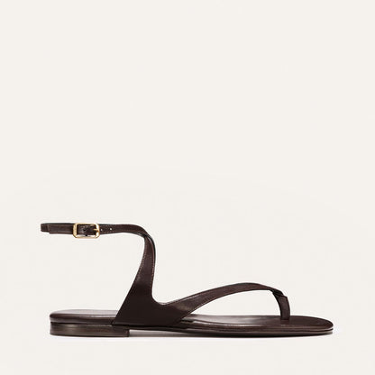 Brown sandal with a thin strap on a light beige background