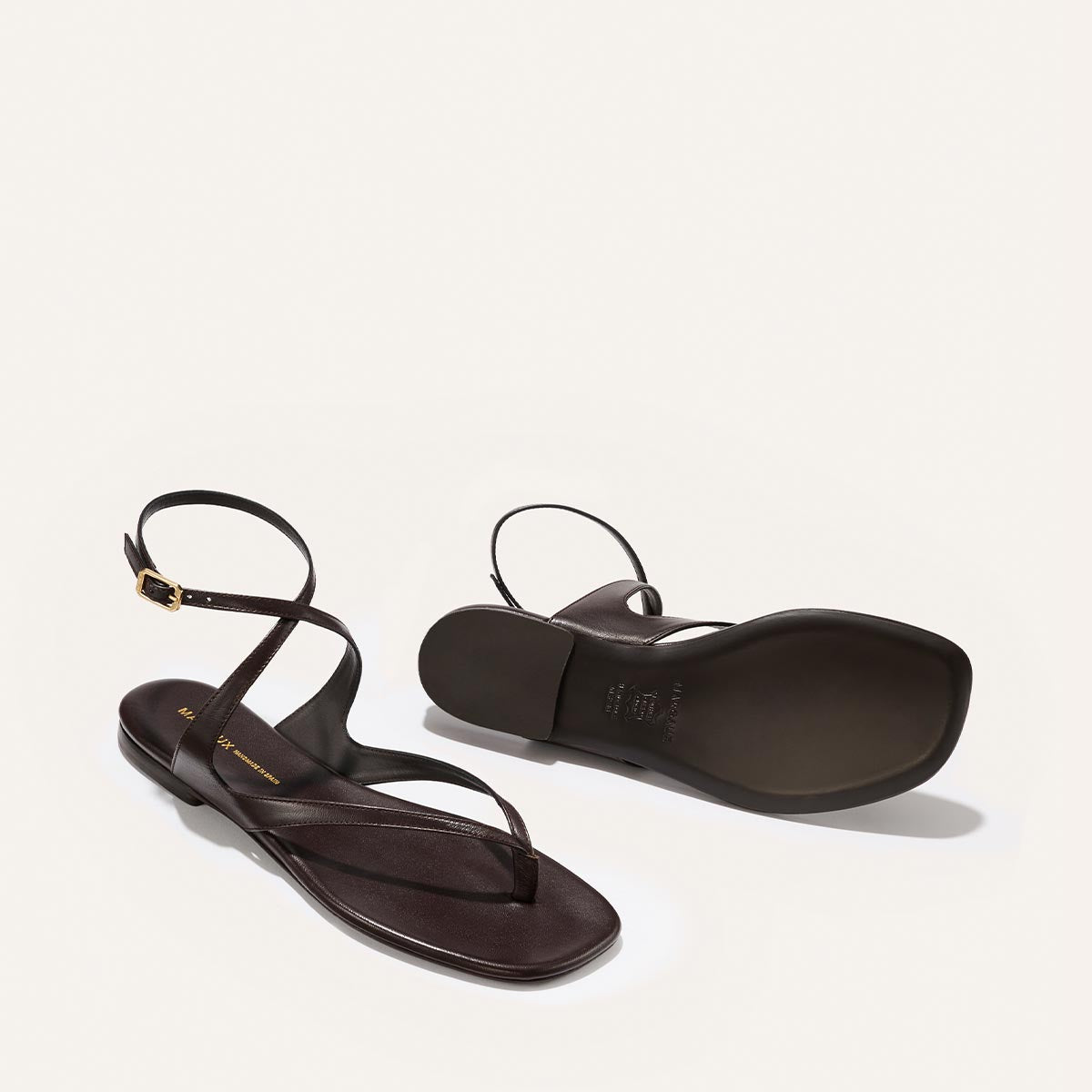 Pair of brown sandals on a light grey background