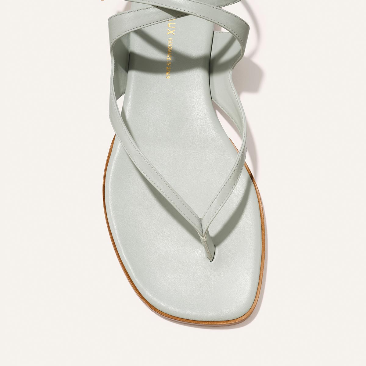 The Palermo Sandal - Sky Nappa light blue leather sandals featuring wraparound ankle straps, a thin sole, and a cushioned insole for summer footwear.