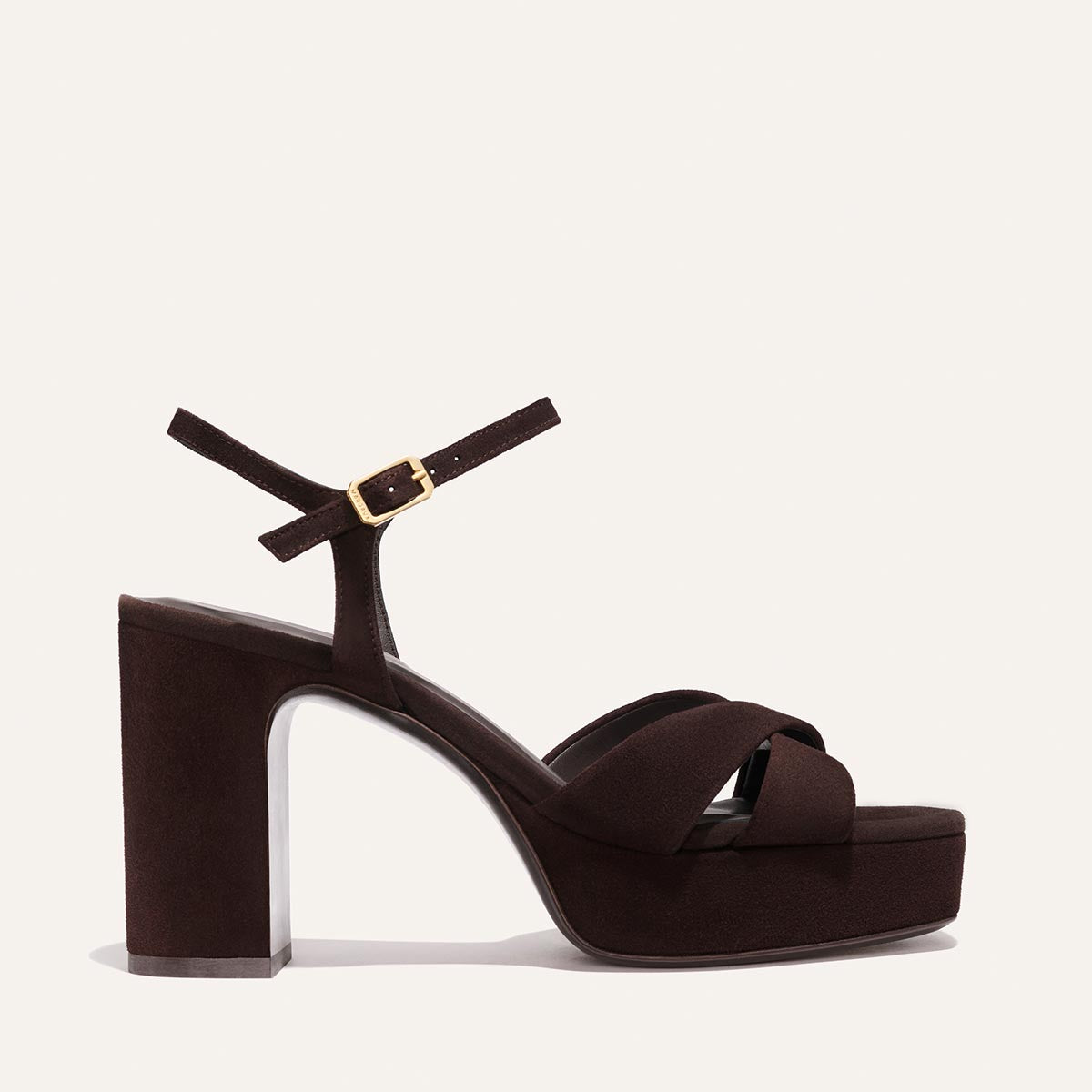 The Paloma Platform - Espresso Suede by Margaux is a dark brown event sandal with a thick block heel, padded platform sole, crisscrossed toe straps, and an ankle strap with gold buckle, shown on a plain light background.