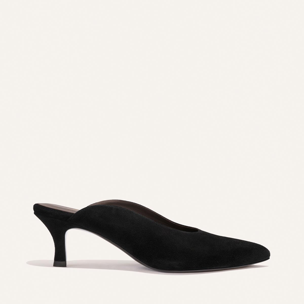 The Alison Roman x Margaux: The Parlor Mule in Black Suede by Margaux features a closed toe, low-cut sides, and a slender high heel, shown against a plain light background.