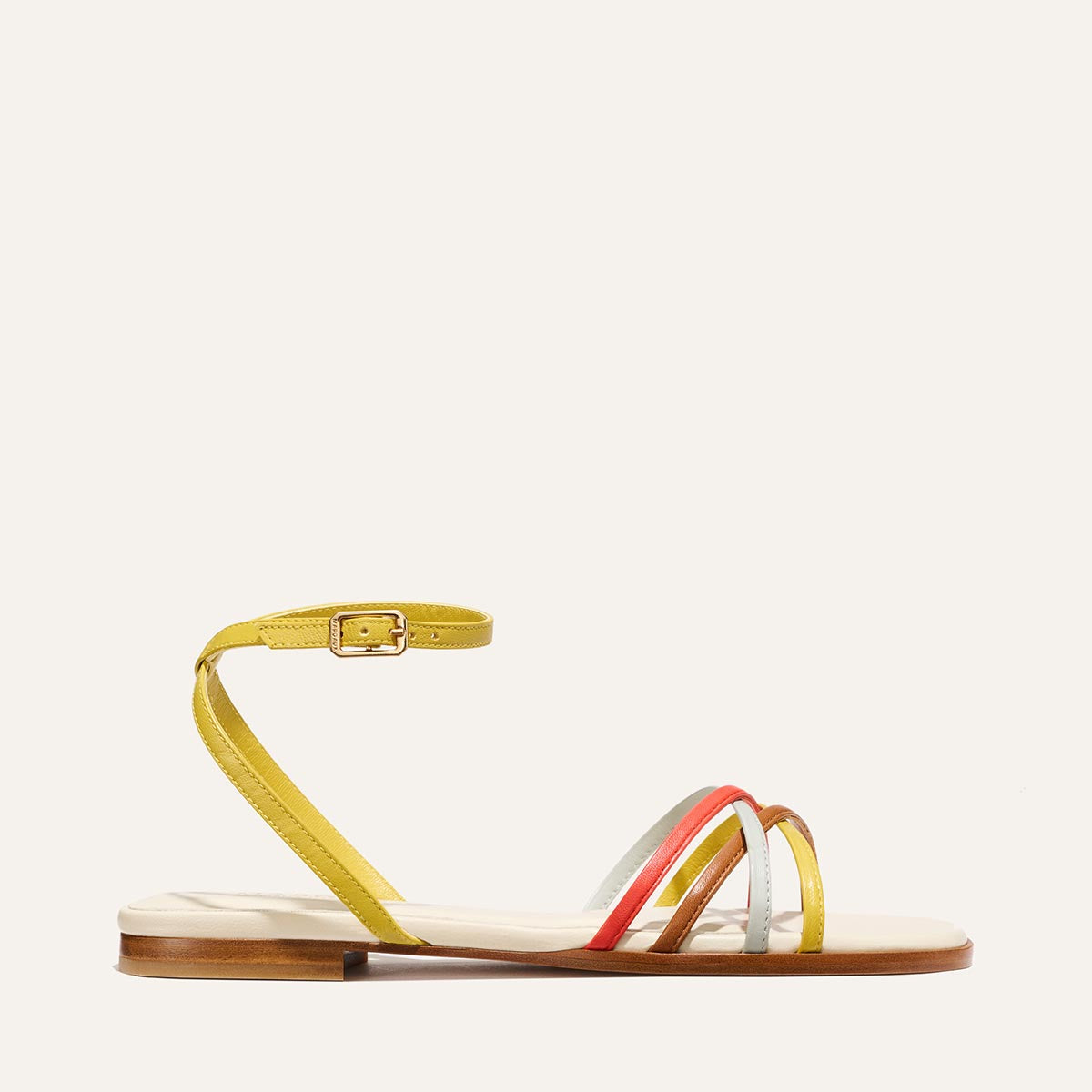 The Paros Sandal by Margaux features yellow ankle buckle, sole edge, and three slim front straps in yellow, orange, and light blue multicolor nappa—blending playful hues with Julia Berolzheimer's signature minimalist style.