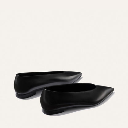 The Parra - Black Nappa flats by margaux-development feature a sleek, pointed-toe design in black, elegantly displayed on a light background.
