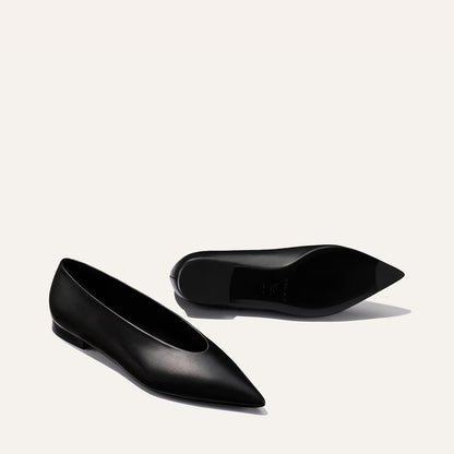 The Parra - Black Nappa flats by margaux-development are shown on a light background: one stands upright, while the other lies on its side.