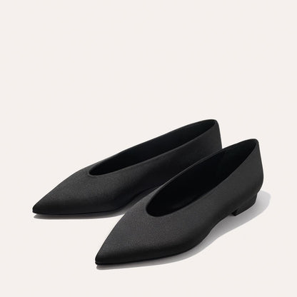 The Parra - Black Satin flats by margaux-development feature a minimalist, pointed-toe design in black, shown on a light background.