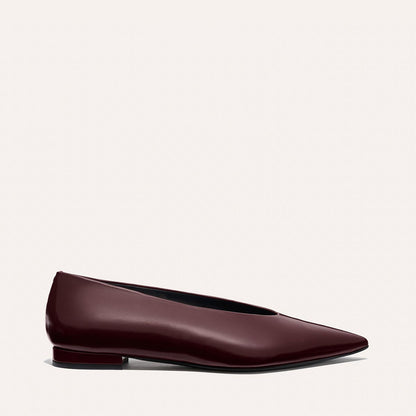 The Parra - Burgundy Calf by margaux-development is a burgundy pointed-toe flat with a high vamp and low heel, crafted from shiny leather in a structured silhouette, shown on a neutral light background.