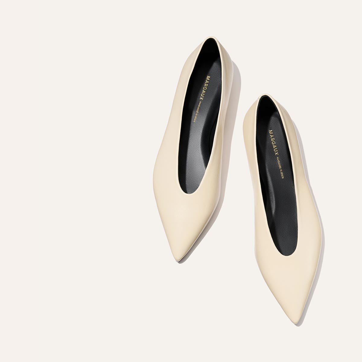 The Parra - Ivoire Nappa by margaux-development: cream-colored pointed-toe flats with black insoles, shown on a simple light background.