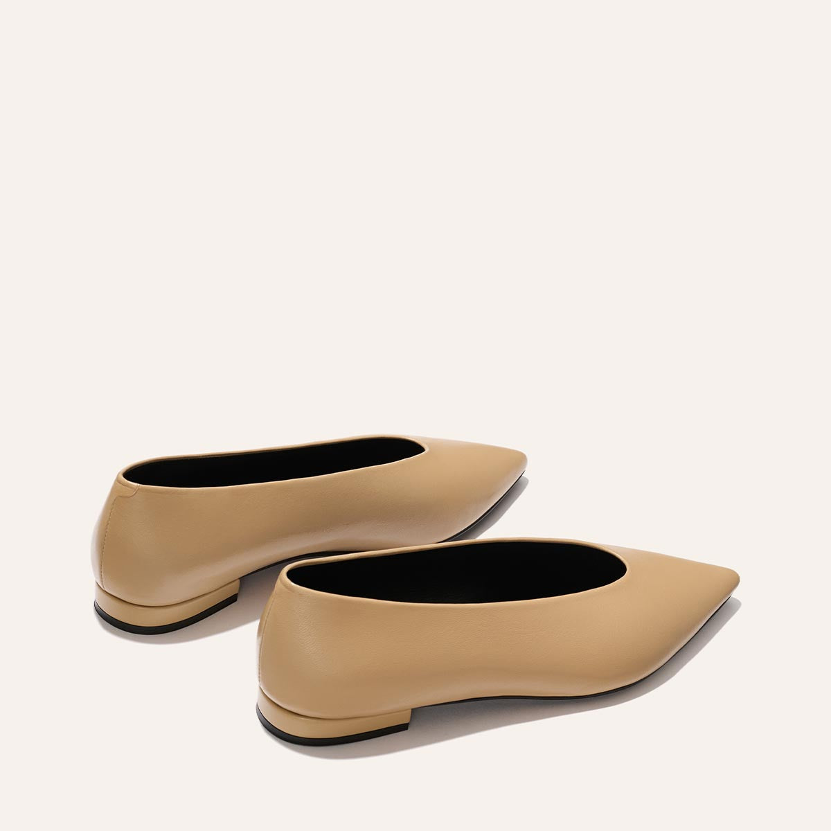 The Parra - Praline Nappa by margaux-development: tan pointed-toe flats with a smooth finish, high vamp, low heel, and structured silhouette, shown on a light beige background.