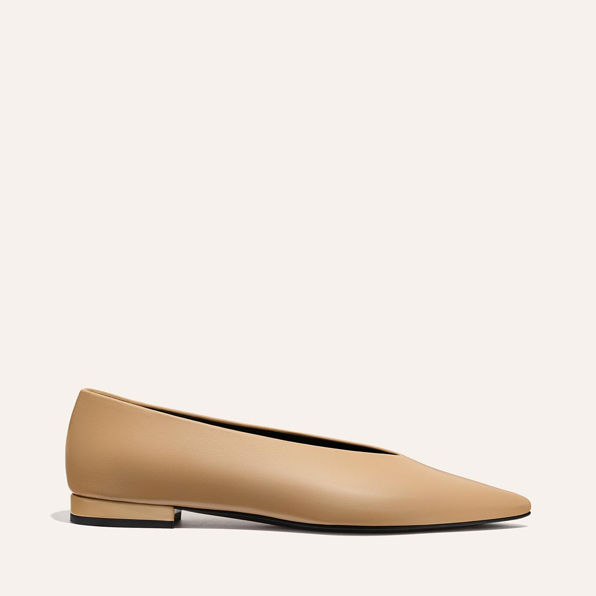 The Parra - Praline Nappa by margaux-development is a tan, minimalist women’s pointed-toe flat with a high vamp, low heel, and structured silhouette, shown in profile on a plain light background.
