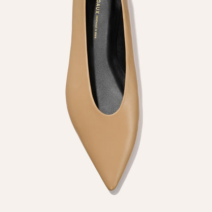 A top view of The Parra - Praline Nappa flat by margaux-development features a tan pointed toe, structured silhouette, and black insole against a light background.