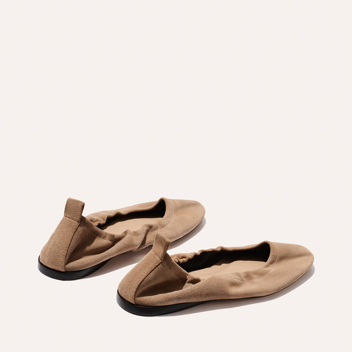The Pascale - Cameo Suede by Margaux: beige suede ballet flats with elasticized backs and black soles, showcased on a light neutral background. Soft, comfortable, and designed with a minimal, modern aesthetic.