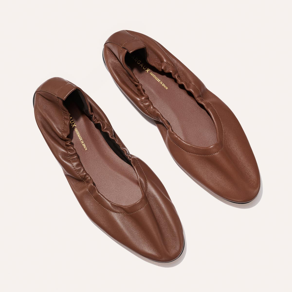 The Pascale - Cognac Nappa by Margaux: brown leather ballet flats with gathered, elasticized edges and almond-shaped toes, shown on a light background.