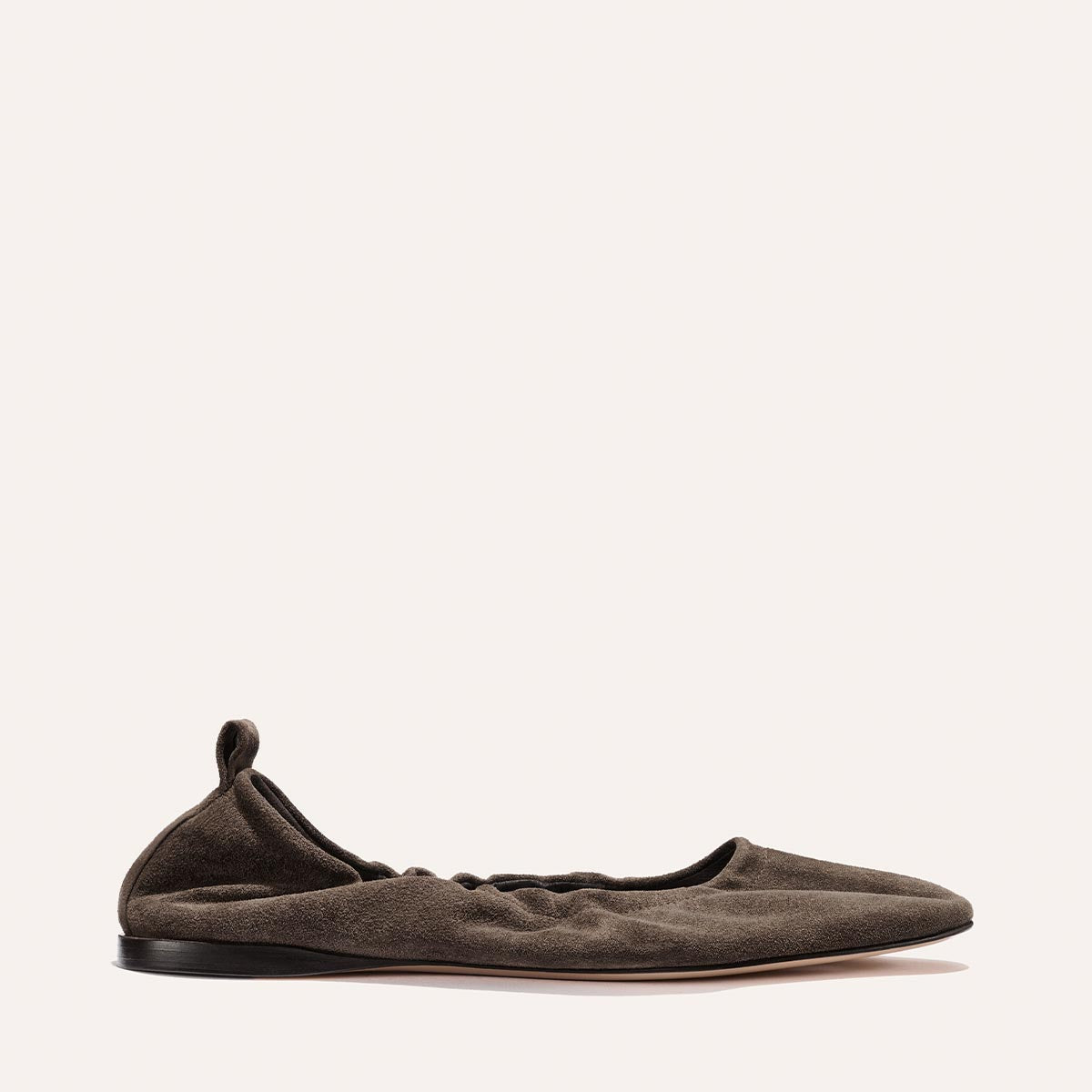 The Pascale - English Brown Suede by Margaux is a single dark brown suede ballet flat, featuring a softly ruched design, black sole, and an elasticated back with a small pull tab at the heel, displayed against a plain light background.
