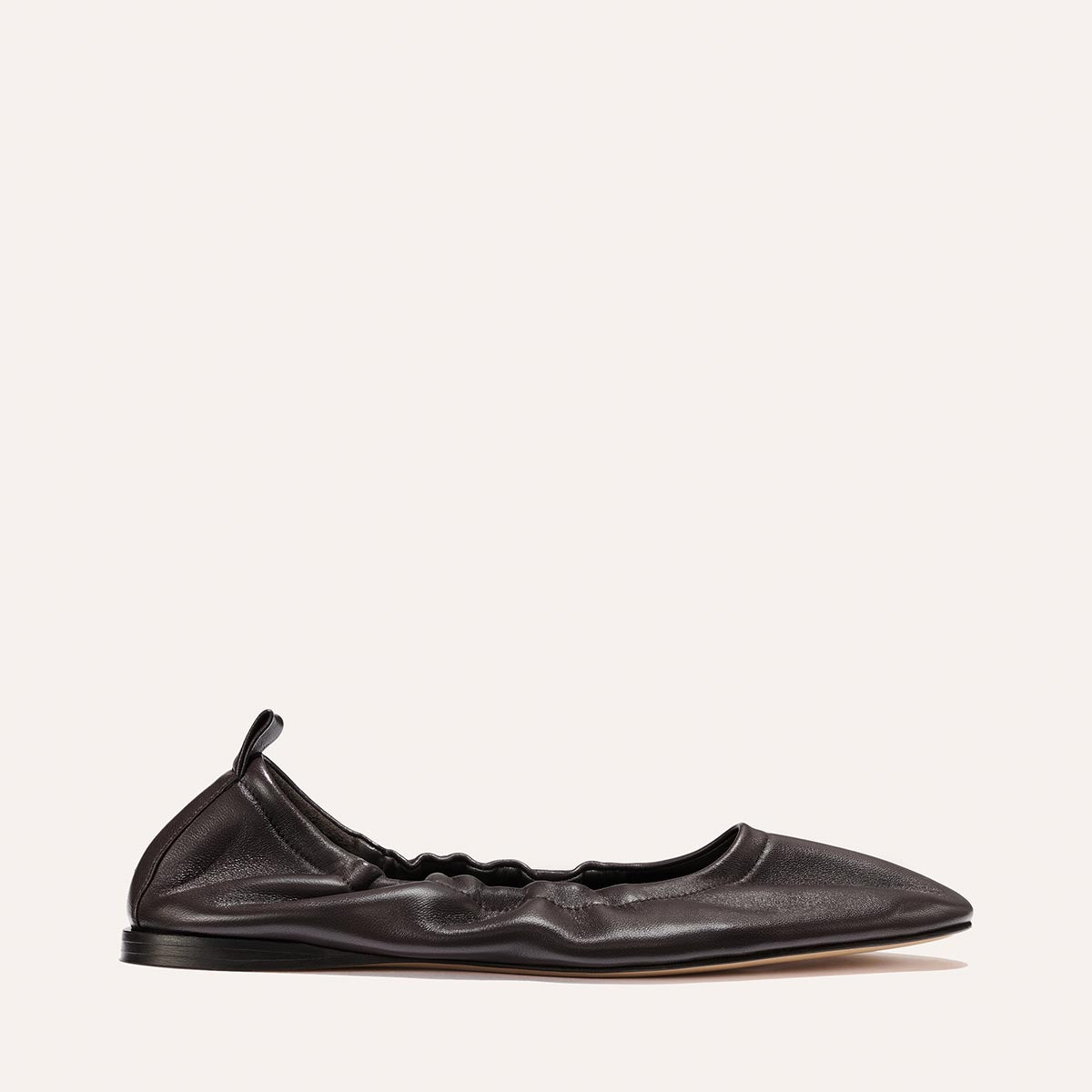 The Pascale - Espresso Nappa by Margaux is a black leather deconstructed ballet flat crafted from supple leather, featuring a ruched, gathered design with a pointed toe and an elasticated back with a small pull tab, displayed against a plain light background.