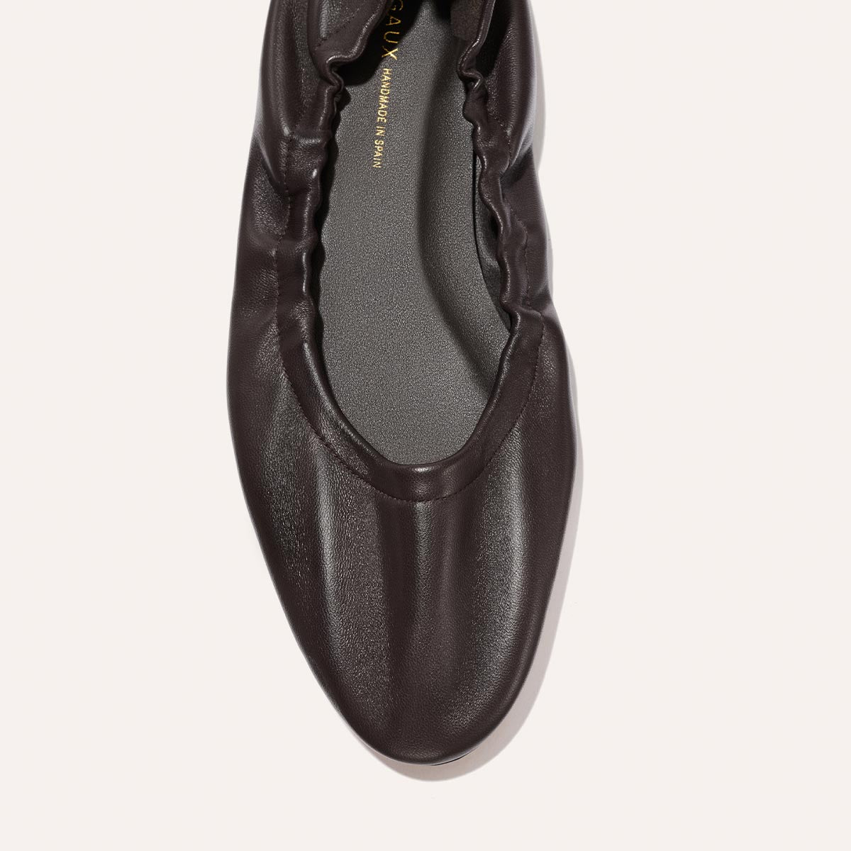 A close-up top view of The Pascale - Espresso Nappa by Margaux, a dark brown supple leather ballet flat featuring a ruched, gathered edge around the opening, an elasticated back for added comfort, and a smooth, rounded toe.