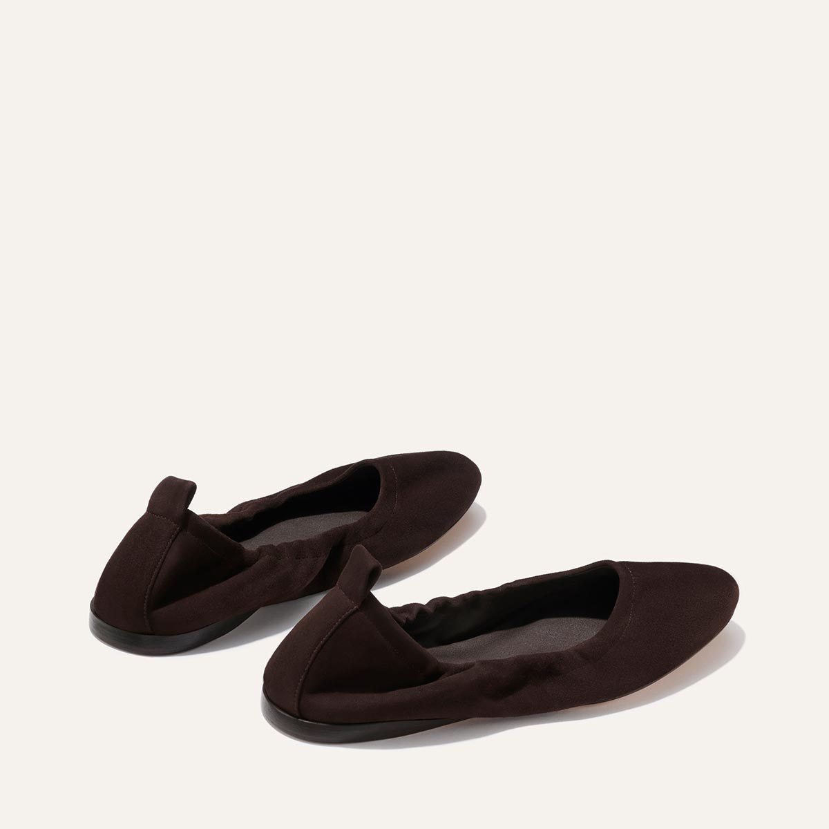 The Pascale - Espresso Suede by Margaux: a pair of brown suede ballet flats with elasticized backs and pull tabs, shown on a plain light background.