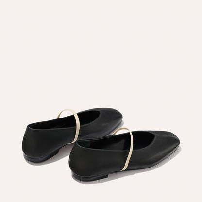 The Phoebe - Black and Ivory Nappa by margaux-development: handmade black ballet flats with cream straps crossing the instep, crafted using sacchetto construction and displayed on a light background.