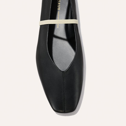 The Phoebe by margaux-development in Black and Ivory Nappa: a deconstructed flat with sacchetto construction, black leather, square toe, and a thin beige instep strap, shown top-down on a light background.