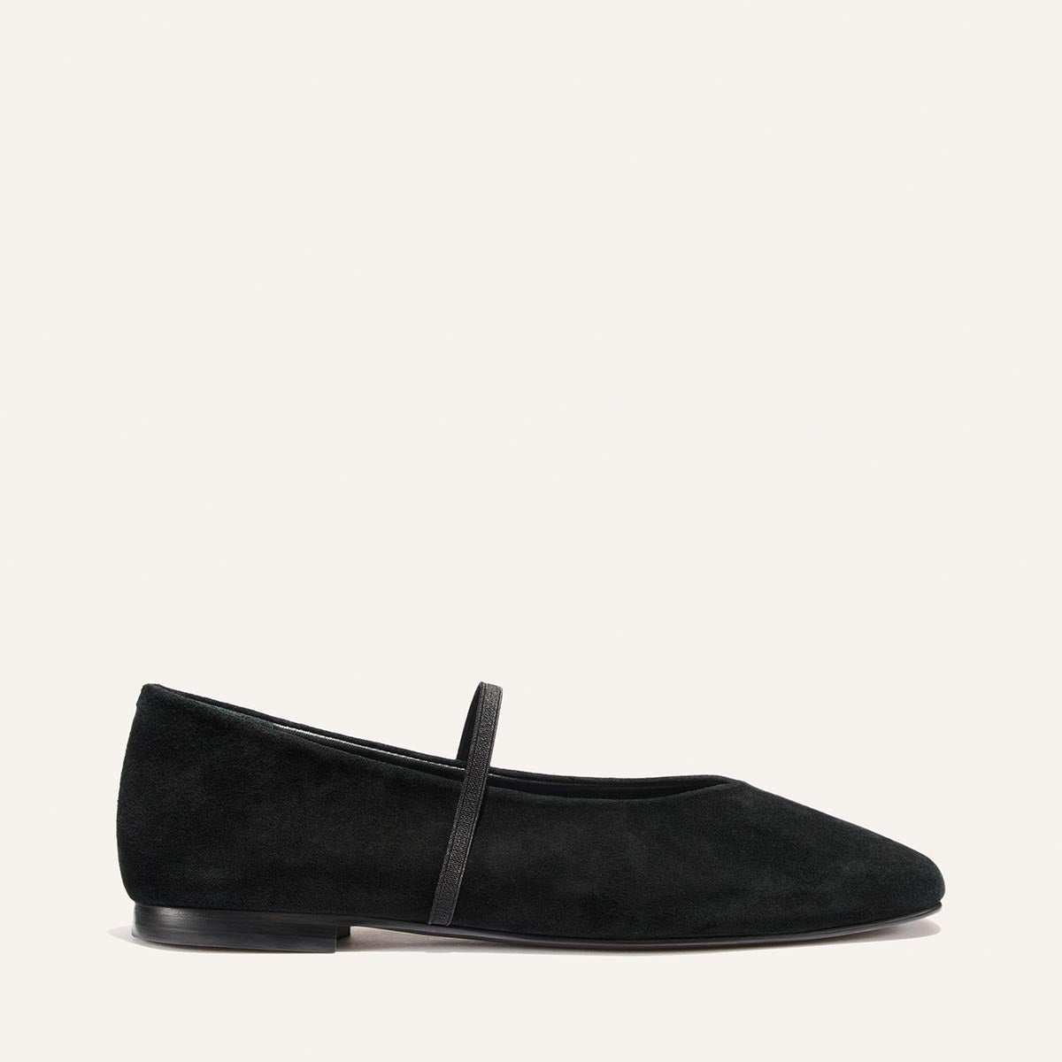The Phoebe - Black Suede ballet flat features a thin strap across the instep, a low heel, and sacchetto construction.