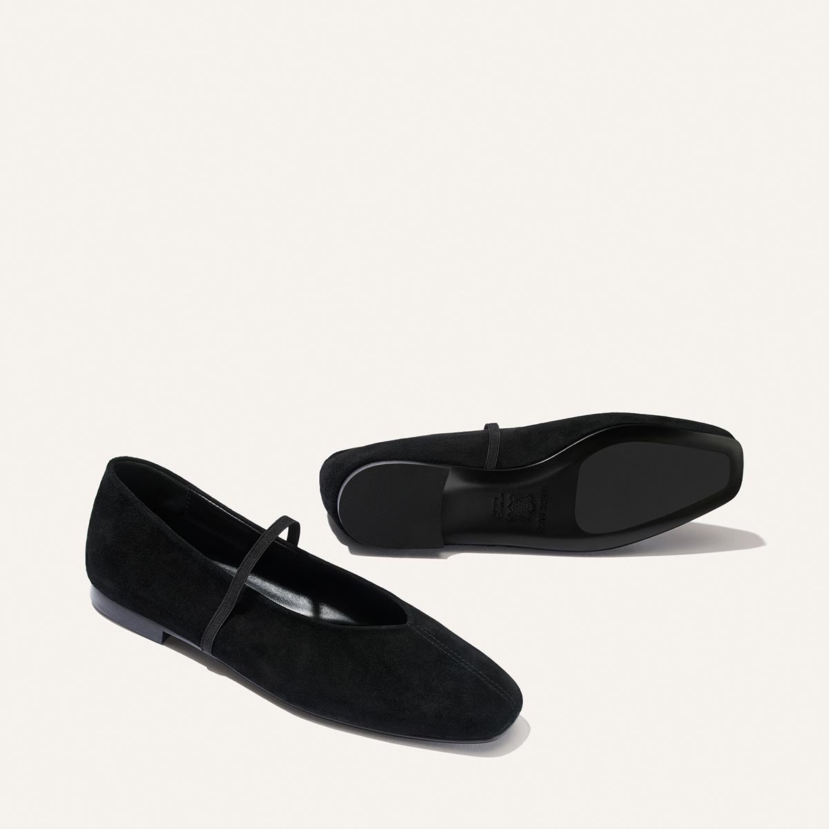 Side and sole view of The Phoebe - Black Suede flat shoes, featuring black suede, a thin strap, and comfortable sacchetto construction.