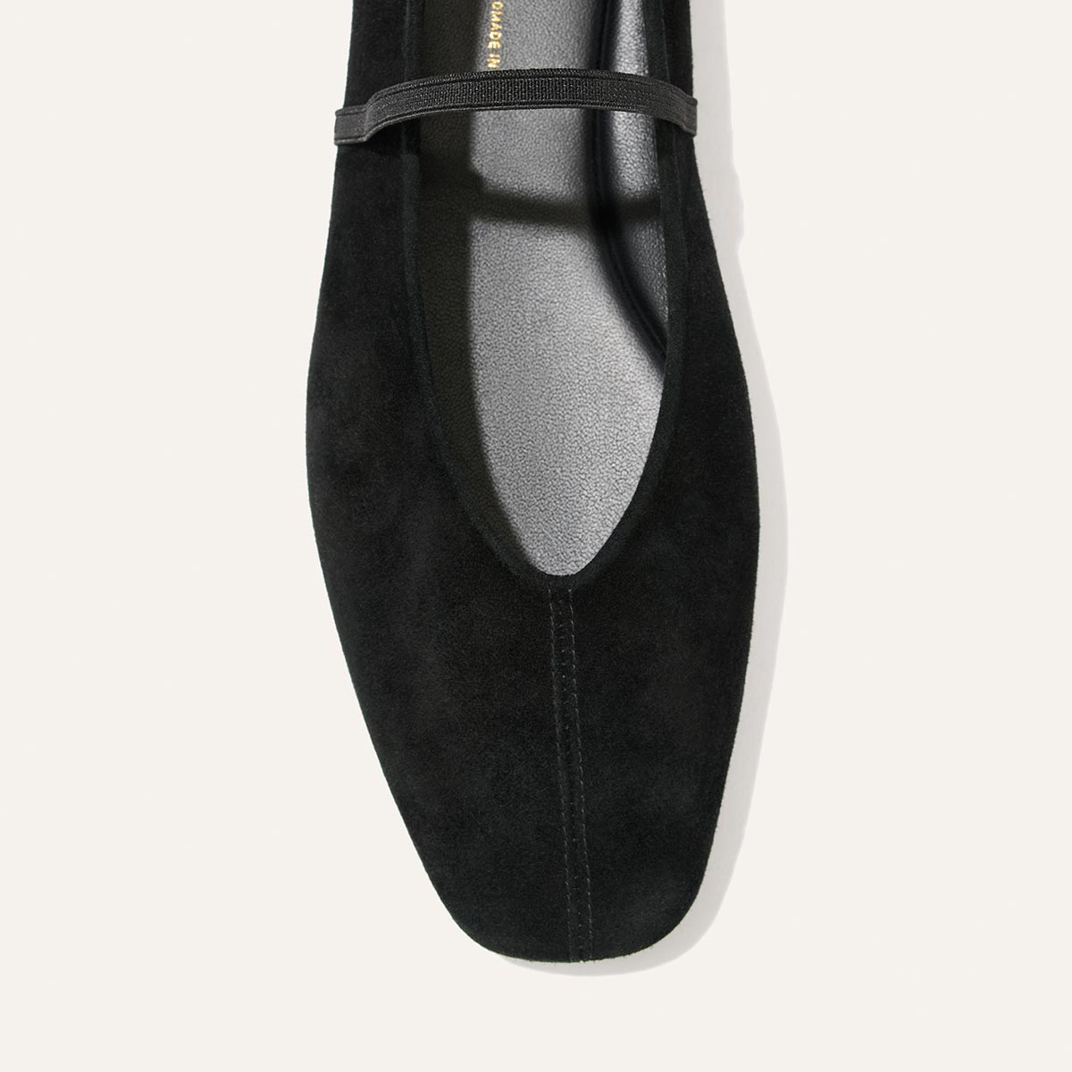 The Phoebe - Black Suede flat shoe featuring a square toe, thin elastic strap, and comfortable sacchetto construction.