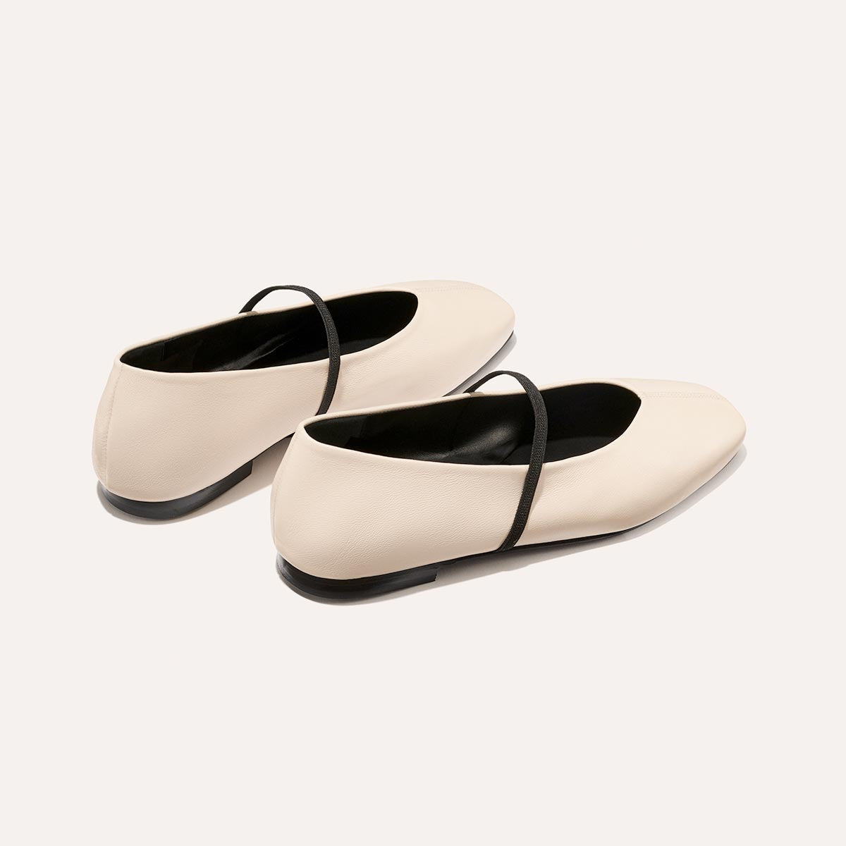 The Phoebe in smooth Bone Nappa leather, a ballet flat with a squared off toe, high vamp and elastic Mary Jane strap.