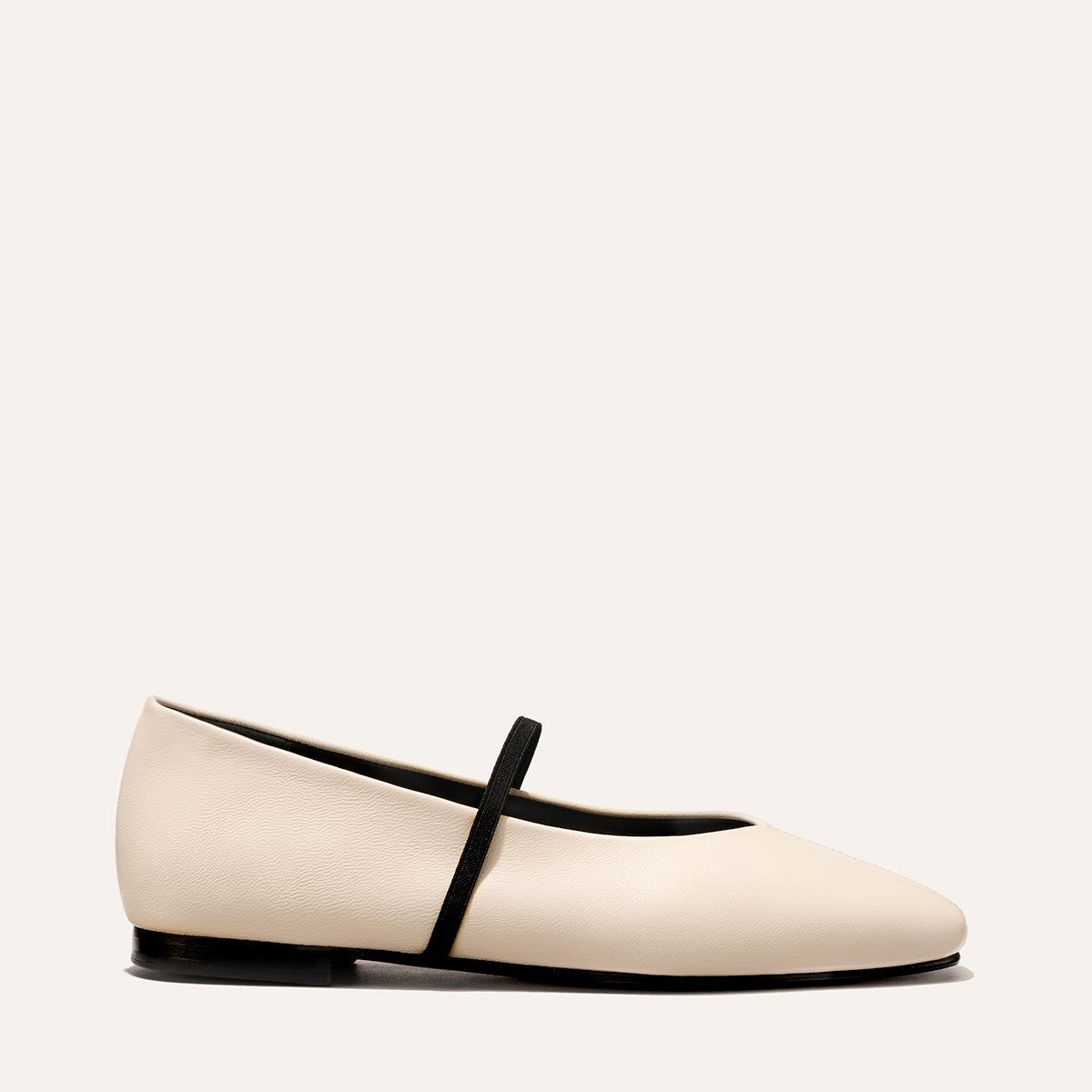 The Phoebe in smooth Bone Nappa leather, a ballet flat with a squared off toe, high vamp and elastic Mary Jane strap.