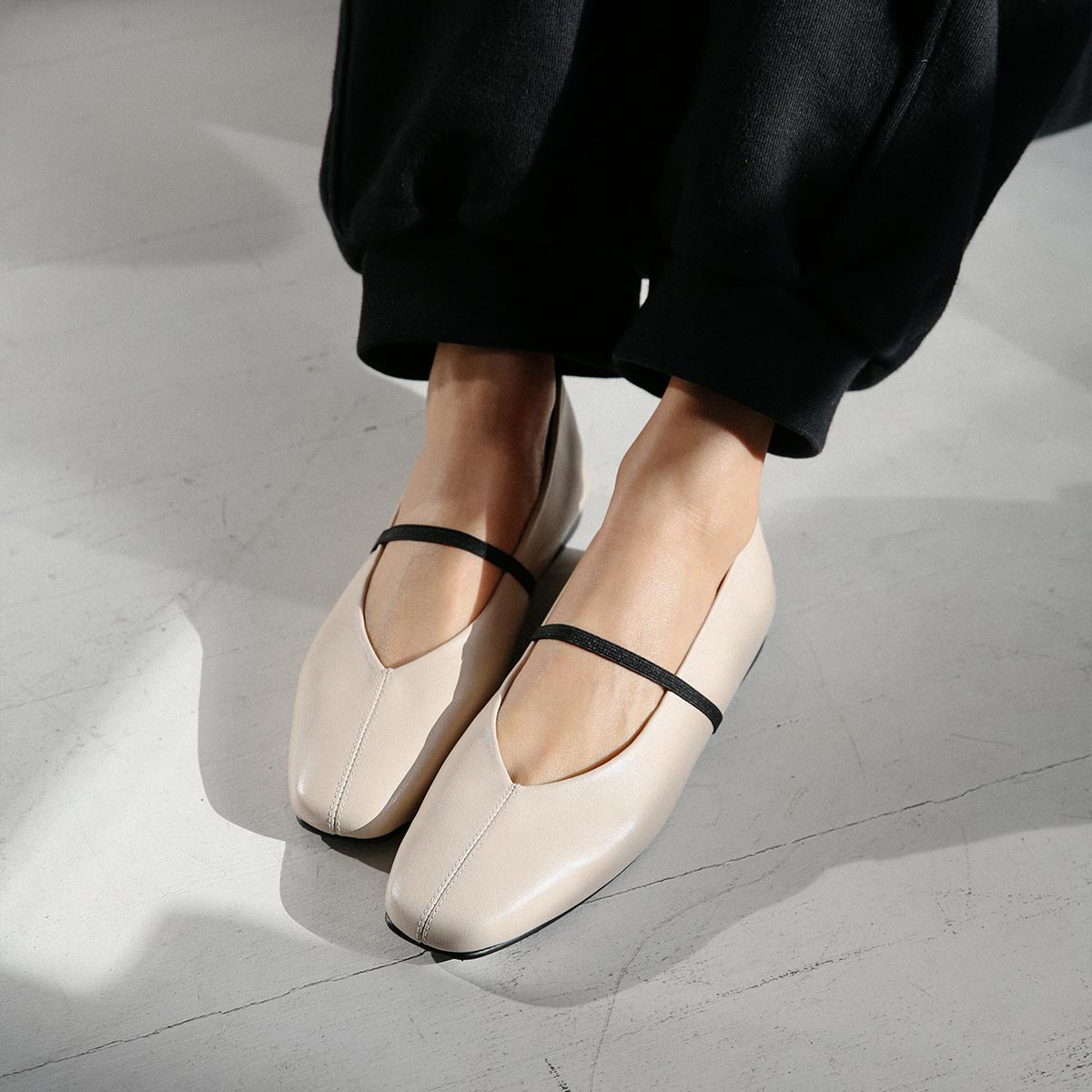 The Phoebe in smooth Bone Nappa leather, a ballet flat with a squared off toe, high vamp and elastic Mary Jane strap.