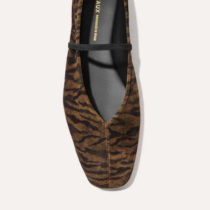 A close-up, top view of The Phoebe - Brown Zebra Suede by Margaux: a brown flat with black zebra stripes, pointed toe, and thin black front strap.