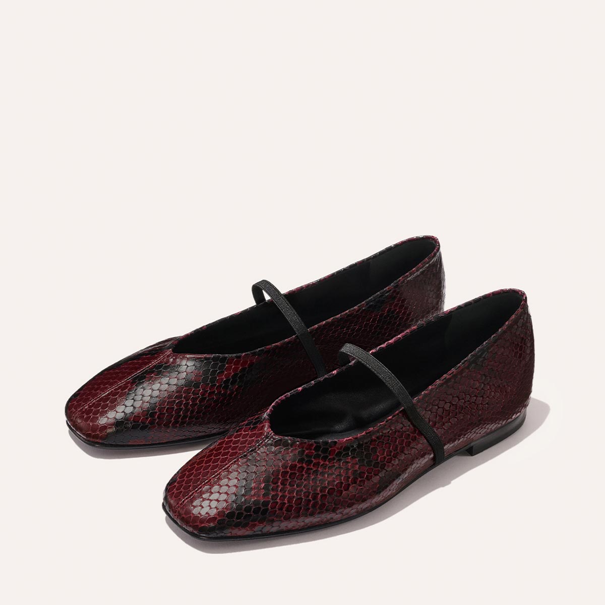 The Phoebe - Burgundy Python Embossed by margaux-development are burgundy and black snakeskin-textured ballet flats with square toes, thin black straps, and soft sacchetto construction for ultimate comfort.