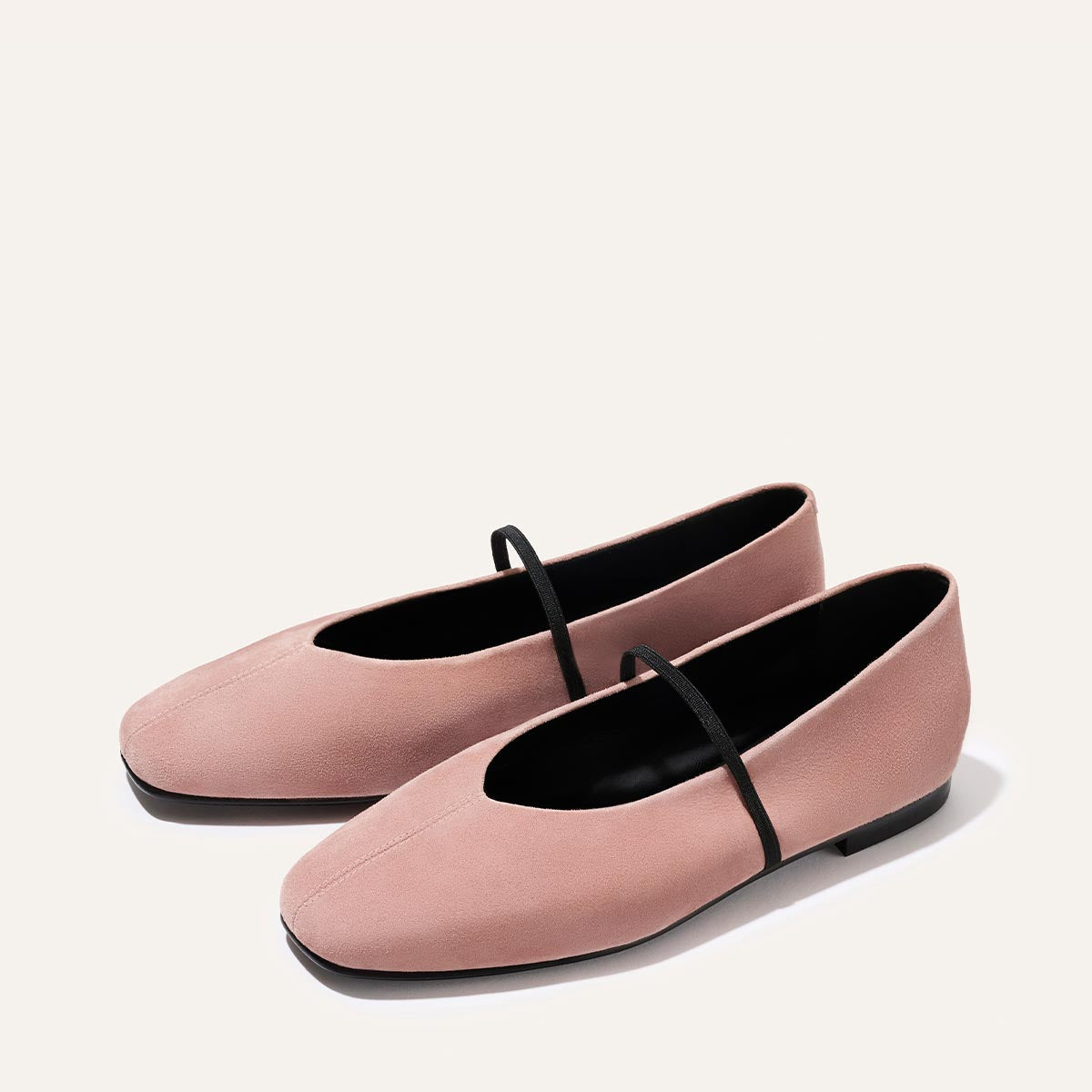 The Phoebe - Dusty Rose Suede by margaux-development: pink suede ballet flats with sacchetto construction, a black elastic top strap, black soles, and a minimalist design shown on a plain light background.