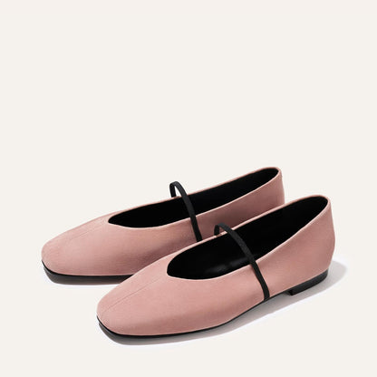 The Phoebe - Dusty Rose Suede by margaux-development: pink suede ballet flats with sacchetto construction, a black elastic top strap, black soles, and a minimalist design shown on a plain light background.