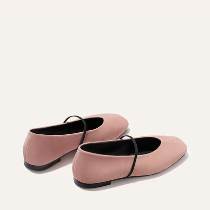 The Phoebe - Dusty Rose Suede by margaux-development: blush pink suede handmade flats with thin black instep straps, black soles, and sacchetto construction for a soft fit, shown on a light neutral background.