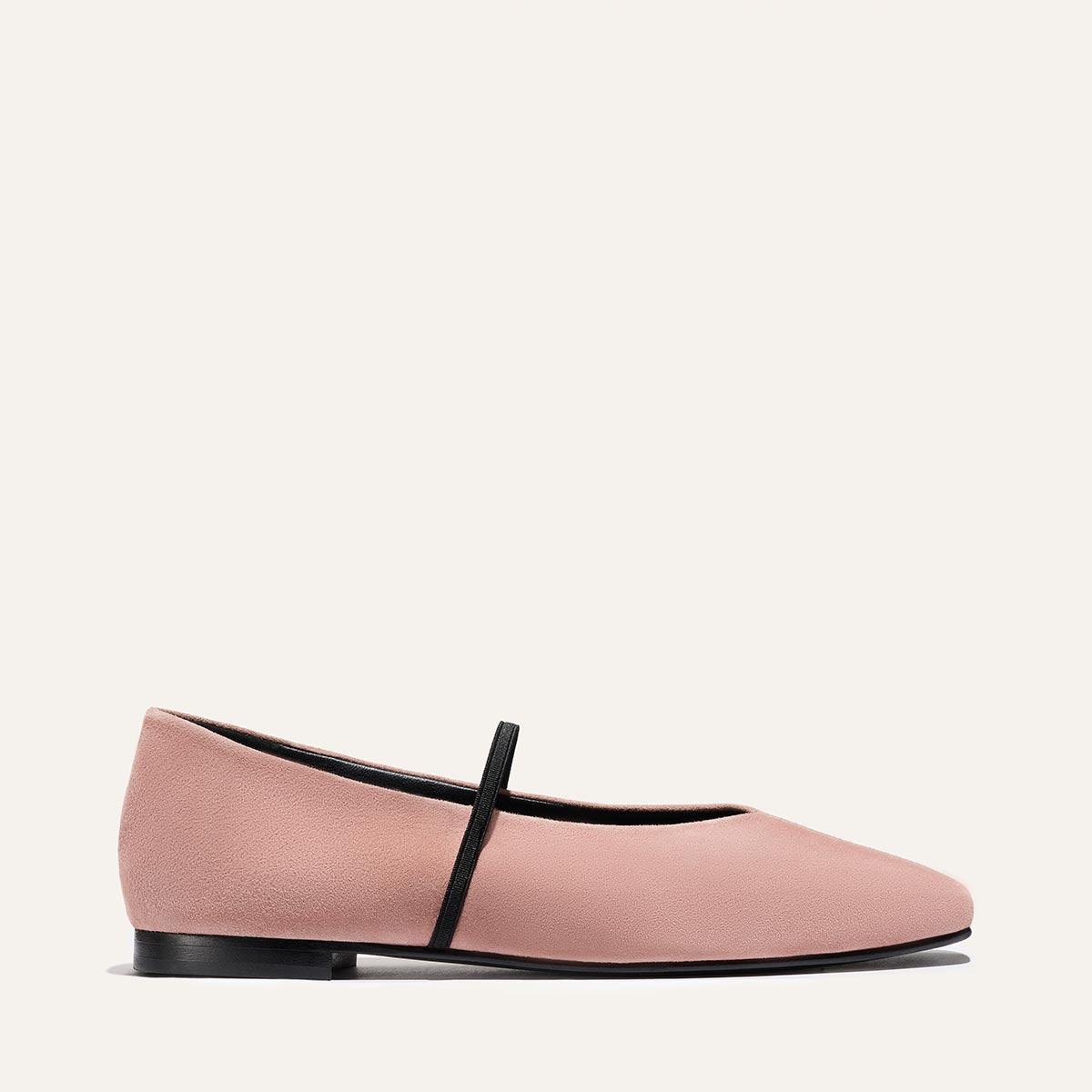 The Phoebe - Dusty Rose Suede by margaux-development is a single pale pink ballet flat with a rounded toe, black sole, and thin black instep strap, crafted with sacchetto construction for comfort and shown on a plain light background.