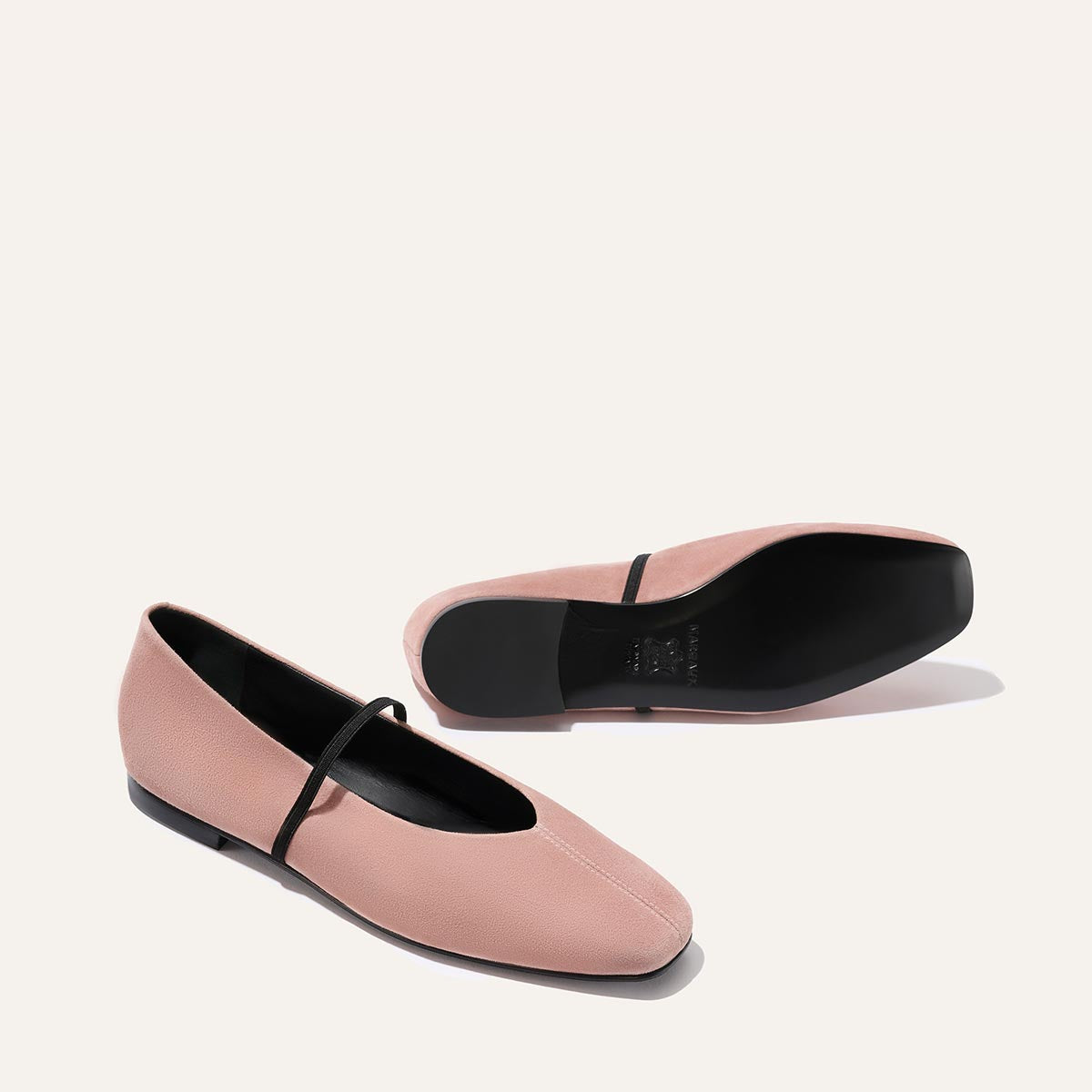 The Phoebe - Dusty Rose Suede by margaux-development: pink ballet flats with sacchetto construction, a black top strap, black soles, and minimalist style. Displayed on a light background—one upright, one on its side.