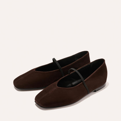 The Phoebe - Espresso Suede by margaux-development: brown suede ballet flats with black soles and a thin black strap, expertly crafted with sacchetto construction for exceptional comfort, shown on a light background.