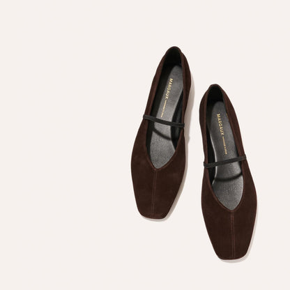 The Phoebe - Espresso Suede by margaux-development: dark brown suede flats with black soles and a slim black strap, sacchetto construction for comfort and flexibility, shown on a light beige background.