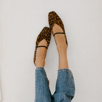 The Phoebe in luxe Leopard Suede, a ballet flat with a squared off toe, high vamp and elastic Mary Jane strap shown styled with jeans.