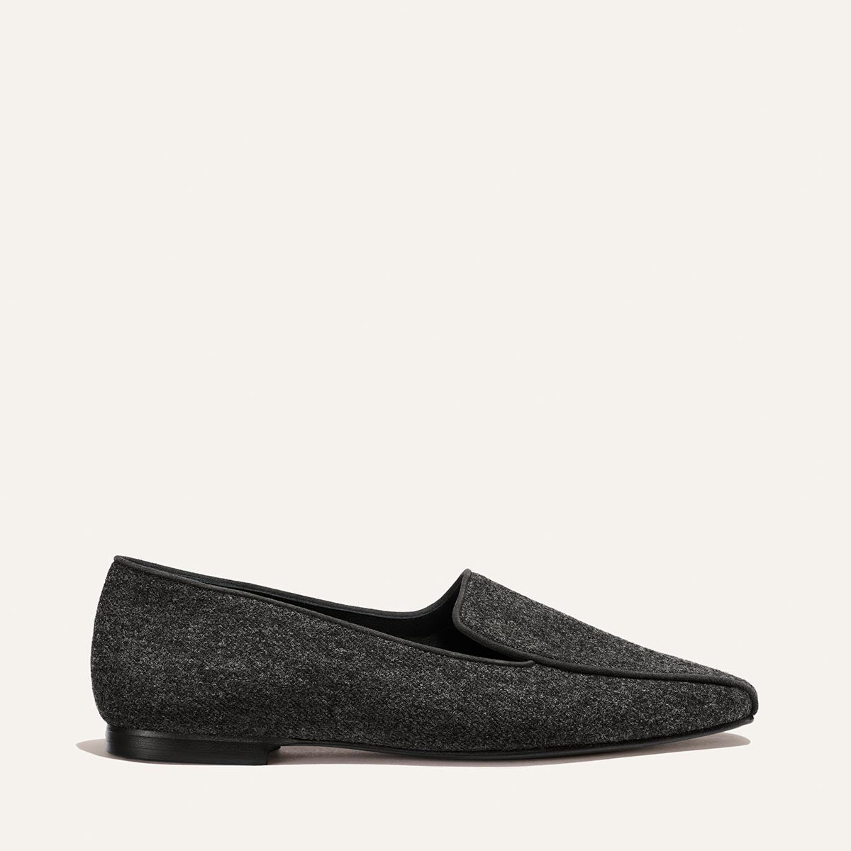 The Portia Loafer - Grey Flannel, a grey flannel loafer with a low heel and black trim.
