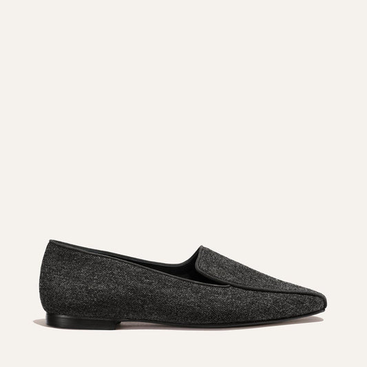 The Portia Loafer - Grey Flannel, a grey flannel loafer with a low heel and black trim.