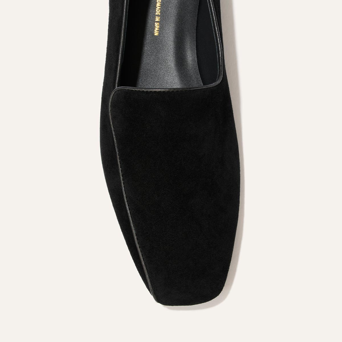 A top-down close-up of The Portia Loafer in black suede by Margaux, featuring a square toe and set against a light background.