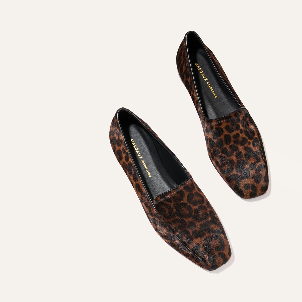 A pair of The Portia Loafer - Chocolate Leopard Haircalf loafers with square toes and black inner soles.