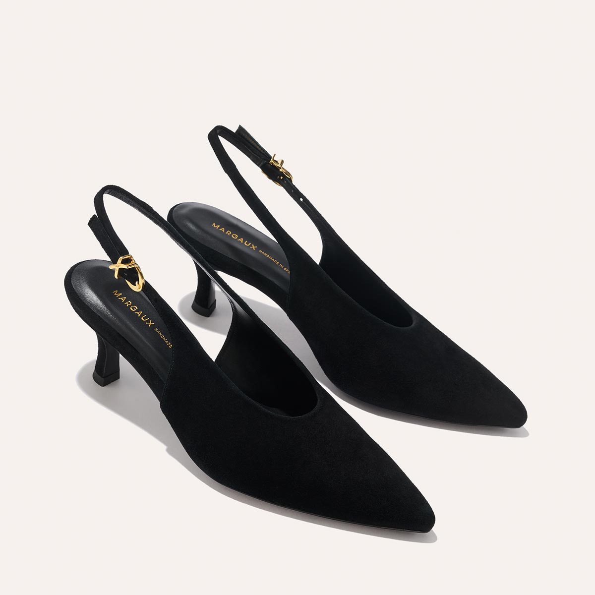 The Prado Sling - Black Suede by margaux-development: black suede slingback heels with pointed toes, low kitten heels, and adjustable gold-buckle straps, shown against a light background.