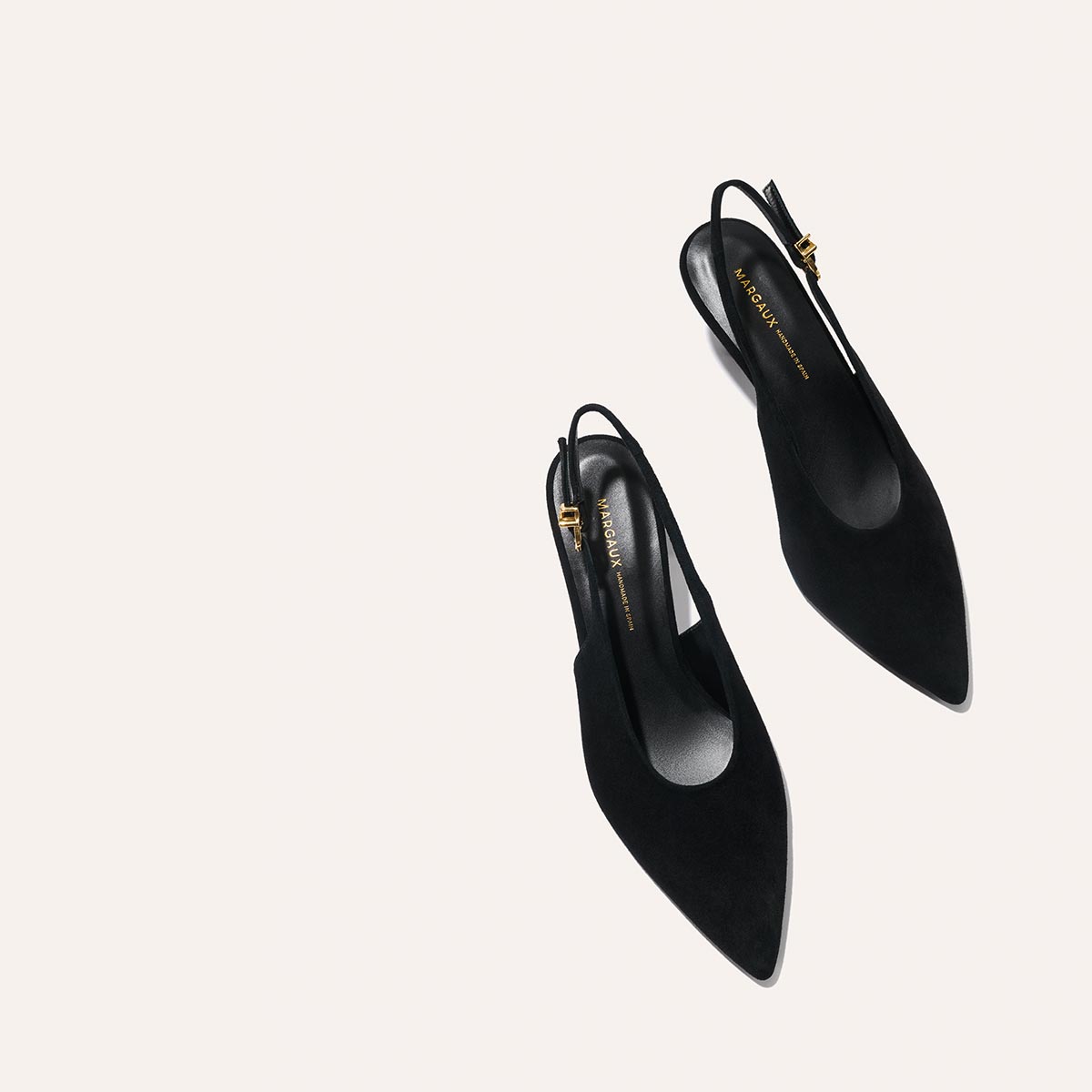 The Prado Sling - Black Suede by margaux-development: black pointed-toe slingback heels with a gold buckle, shown on a light background.